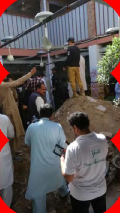 People walking around a mound of debris in the middle of a building.