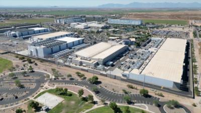 An aerial image of data centres, long grey buildings - mountains in the background. 