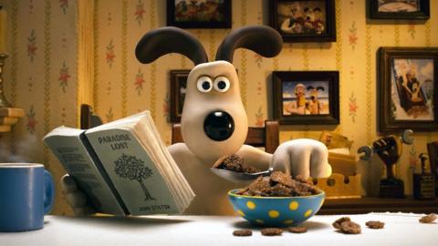 Gromit looks surprised while eating a bowl of cereal and reading Paradise Lost by John Stilton