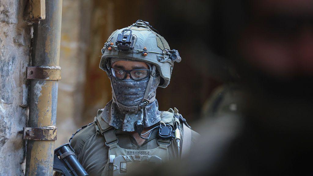 An armed Israeli soldier wearing a face scarf looks on in the Old City of Hebron, occupied West Bank on October 10, 2026. 