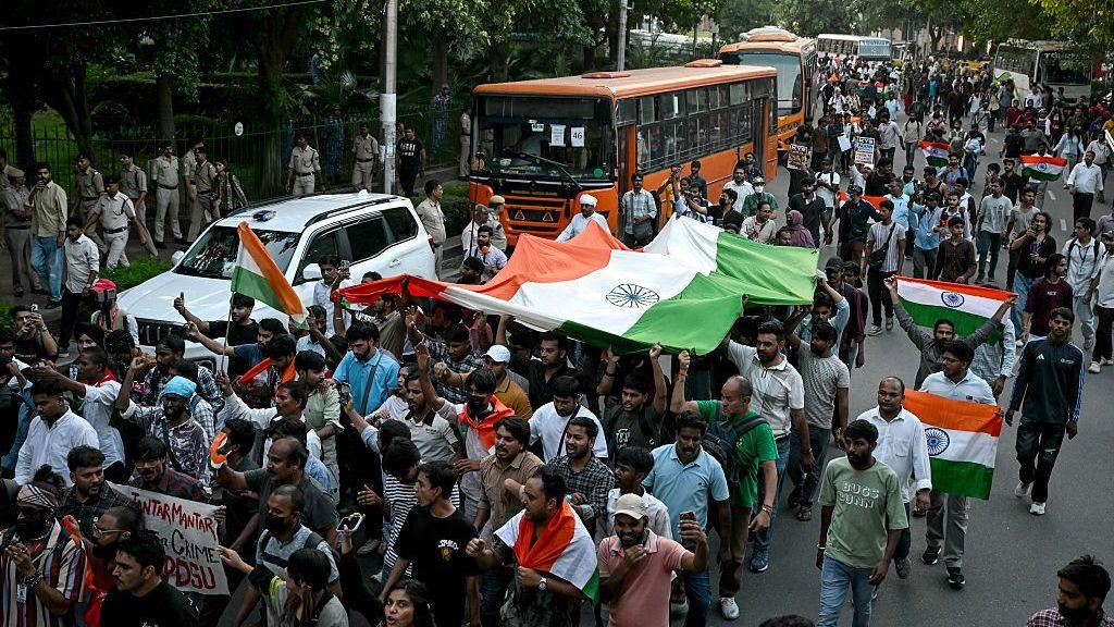 Cockroach Janta Party (CJP) supporters holding the country's national flags march during a protest demanding India's Chief Election Commissioner Gyanesh Kumar's resignation over alleged voter roll irregularities linked to the "special intensive revision" (SIR), at Connaught Place in New Delhi on October 16, 2026. 