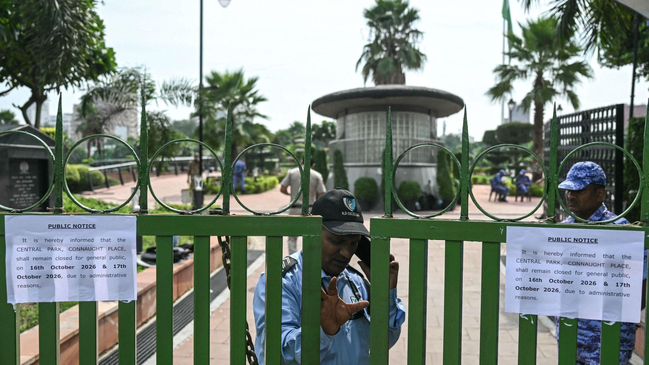 A security guard stands at the entrance of the closed central park at Connaught Place in New Delhi on October 16, 2026 