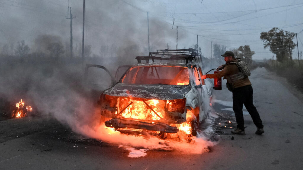 A serviceman extinguishes a burning car that was hit by a Russian FPV drone, amid Russia's attack on Ukraine, in Donetsk region, Ukraine, October 14, 2026.