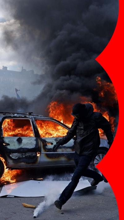 A car burns at Place de la Republique as clashes break out between protesters and police