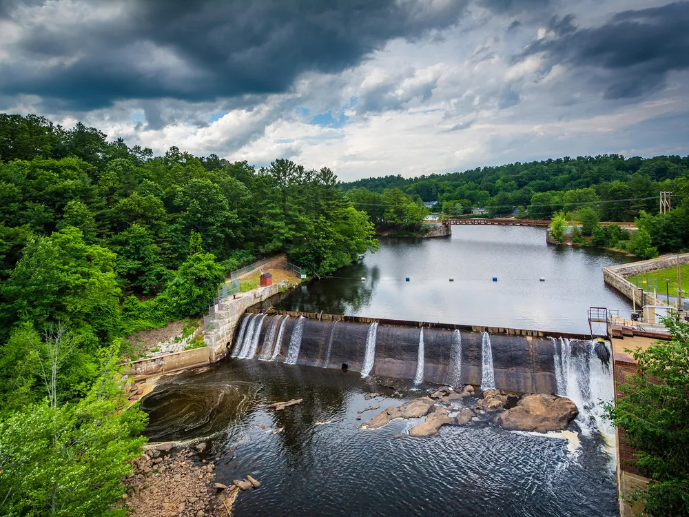 a dam in a river with trees on both sides