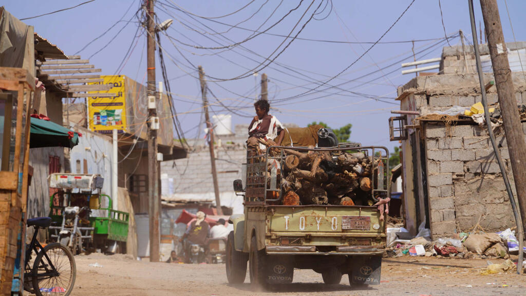 A truck loaded with firewood drives through the Al-Basateen neighborhood in Aden, Yemen