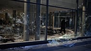 A man takes photos of a looted store after a demonstration against rising living costs, joining students' grievances, in Lyon, France, Saturday, Oct. 17, 2026