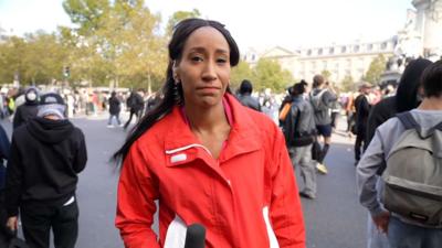 Adina Campbell in a red jacket. Behind her are French policemen and students.