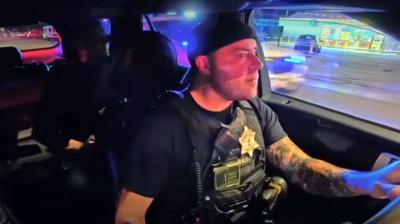 Policeman in the USA driving a patrol car at night ( Clip from footage in the article) 