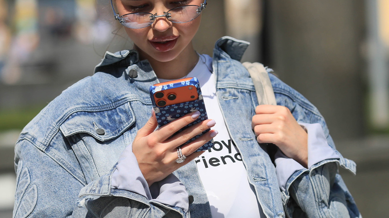 
					A young woman looks at her phone in Moscow.					 					Vasily Kuzmichenok / Moskva News Agency   				