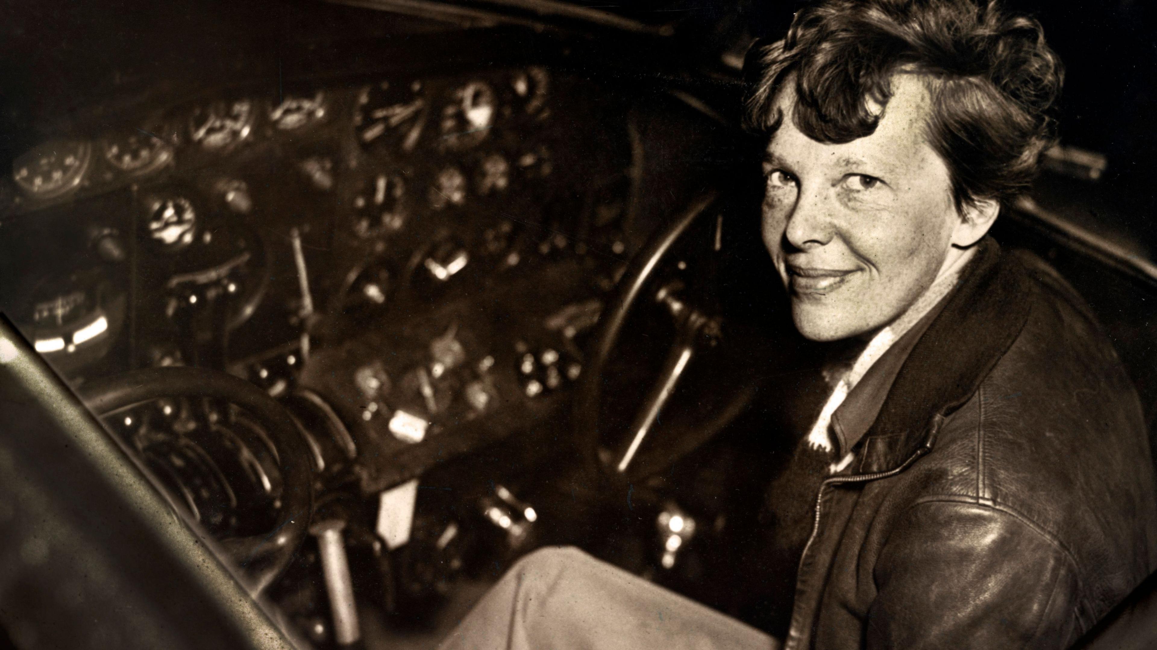 Amelia Earhart sitting in the cockpit of an Electra airplane