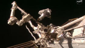 August 25, 2026, frame grab from a NASA live video stream shows NASA astronaut Anil Menon and ESA astronaut Sophie Adenot working during their spacewalk outside the International Space Station.