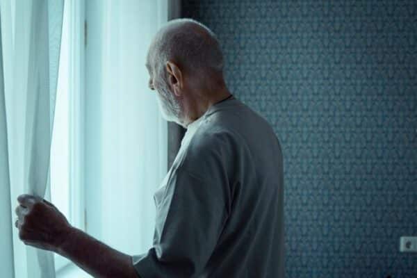 Elderly person looking out the window
