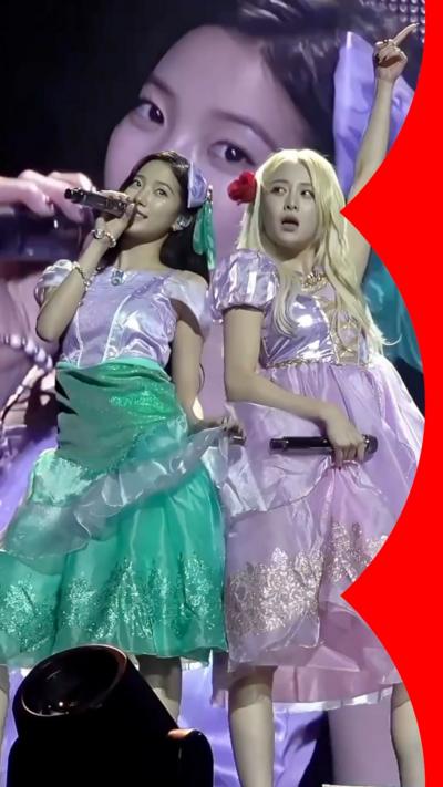 Two women dressed as princesses sing on stage