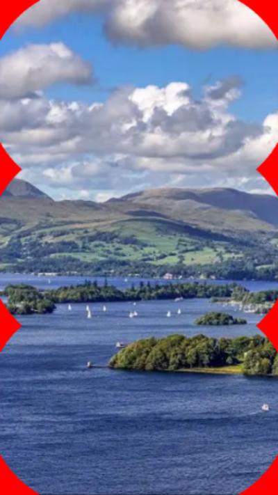 View of Lake Windermere, surrounded by green trees and hills.