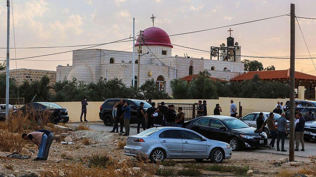 Security officials and public outside Greek Orthodox church where attack happened in Jordan. 