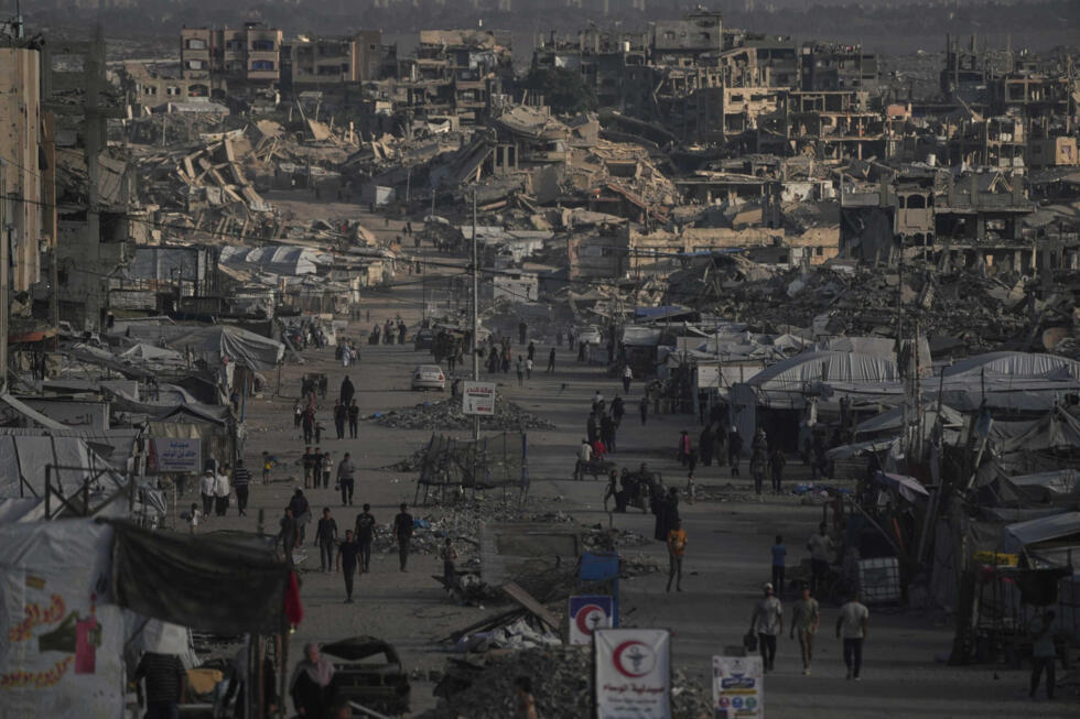 Palestinians walk along a street lined with buildings destroyed during the Israel-Hamas war in Gaza City
