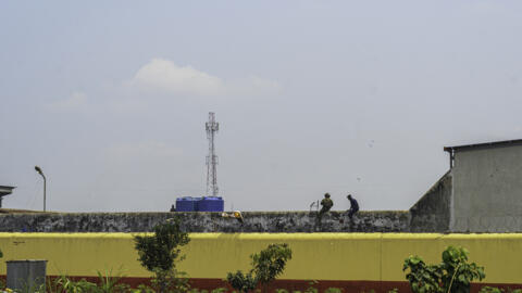 Un policier et un militaire se tenant sur un mur de la prison de Makala, à Kinshasa, le 3 septembre 2024.