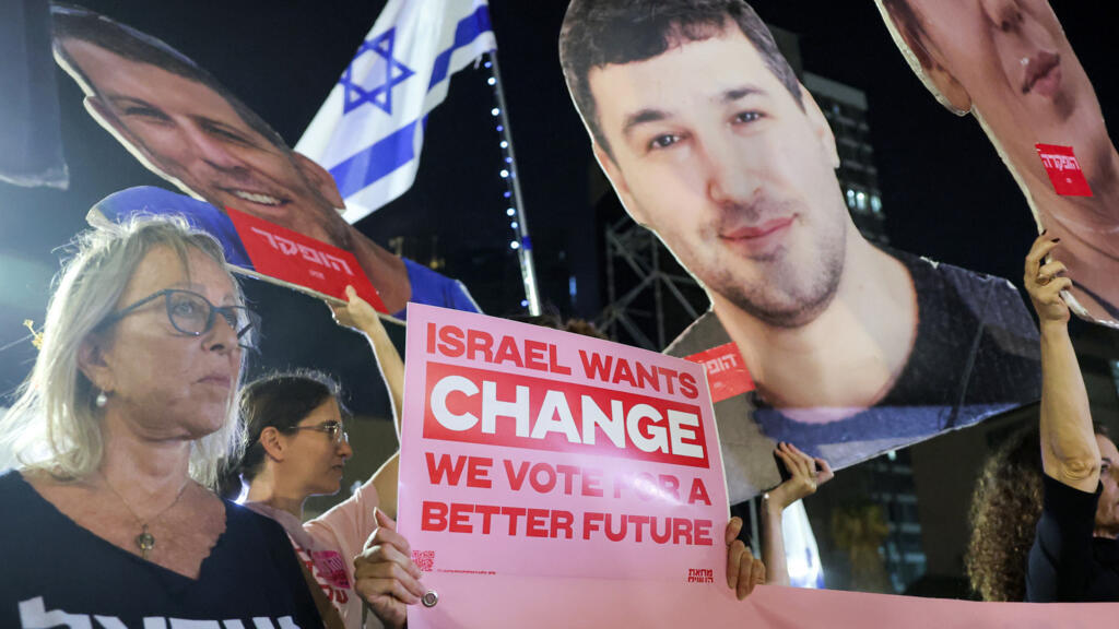 Protesters gather with signs during an anti-government demonstration demanding the formation of a state commission of enquiry into Hamas's October 7, 2023 attack at Hostages Square in Tel Aviv